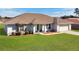 Well-maintained single-story home featuring a green lawn and an attached two-car garage at 8509 Sw 136Th Loop, Ocala, FL 34473