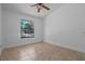 Bedroom features tile flooring, ceiling fan, and natural light from the window at 10030 Cheshunt Dr, Orlando, FL 32817