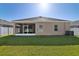 Spacious backyard with lush green grass, screened-in lanai, and privacy fence at 1052 Cascade Dr, Davenport, FL 33837