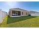 Well-maintained backyard featuring green lawn, white fence, and screened-in lanai at 1052 Cascade Dr, Davenport, FL 33837