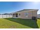 Large backyard featuring healthy green lawn, privacy fence, and screened-in patio area at 1052 Cascade Dr, Davenport, FL 33837