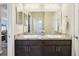 Well-lit bathroom with double sinks, dark wood cabinetry and views to the living area at 1052 Cascade Dr, Davenport, FL 33837