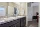Bathroom with double sinks, dark wood cabinetry and views to the bedroom at 1052 Cascade Dr, Davenport, FL 33837