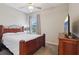 Cozy bedroom with a wooden bed frame, ceiling fan, and dresser at 1052 Cascade Dr, Davenport, FL 33837
