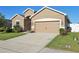 Attractive home exterior with a two-car garage, well-manicured lawn, and curb appeal at 1052 Cascade Dr, Davenport, FL 33837