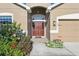 Charming home entrance with a decorative front door, inviting landscaping and attached garage at 1052 Cascade Dr, Davenport, FL 33837