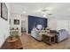 Comfortable living room with a blue accent wall, ceiling fan and light wood flooring at 1052 Cascade Dr, Davenport, FL 33837