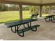 An outdoor picnic area features tables and seating under a covered structure overlooking a large green field at 1052 Cascade Dr, Davenport, FL 33837