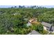 Aerial view of the home, surrounded by lush trees, featuring a pool and with the city skyline in the background at 1110 Greenwood St, Orlando, FL 32801