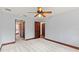 Spacious carpeted bedroom with three doors, ceiling fan and access to hallway at 1110 Greenwood St, Orlando, FL 32801
