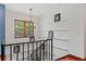 Hallway features wood floors, black iron railing, a window with natural light, and a decorative chandelier at 1110 Greenwood St, Orlando, FL 32801