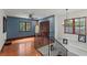 Hallway with blue accent wall, hardwood floors, a surfboard, and black iron railing at 1110 Greenwood St, Orlando, FL 32801