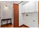 Bright laundry room with white cabinets, wood floors, and stylish wood door at 1110 Greenwood St, Orlando, FL 32801
