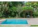Inviting backyard pool featuring lush greenery, a pergola, a BBQ grill, and a tranquil, refreshing atmosphere at 1110 Greenwood St, Orlando, FL 32801