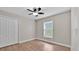 Bedroom with a ceiling fan, window with blinds, closet and wood-look tile flooring at 114 Dolcetto Dr, Davenport, FL 33897