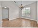 Elegant dining room with wood-style floors, chandelier, and large window offering plenty of natural light at 114 Dolcetto Dr, Davenport, FL 33897