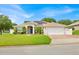 Charming single-story home with a well-manicured lawn, mature landscaping, and a welcoming entryway at 114 Dolcetto Dr, Davenport, FL 33897