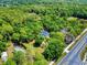 Aerial view of a property nestled among trees, complemented by a view of the adjacent road at 1155 Taylor E Rd, Deland, FL 32724