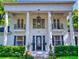 Elegant white home featuring grand columns, a detailed front door, and manicured landscaping at 1155 Taylor E Rd, Deland, FL 32724