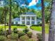 Stately white home featuring elegant columns, a lush yard, and a winding driveway through a wooded lot at 1155 Taylor E Rd, Deland, FL 32724