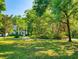 Spacious lawn surrounded by mature trees leading to the white exterior of this home at 1155 Taylor E Rd, Deland, FL 32724