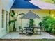 Charming outdoor patio area with a bistro set and striped umbrella, perfect for relaxing and dining al fresco at 1155 Taylor E Rd, Deland, FL 32724