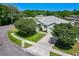 Aerial view of a charming home featuring mature trees, lush lawn, and a well-maintained exterior in a serene neighborhood at 1157 Valley Creek Run, Winter Park, FL 32792