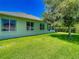 Backyard shot showing the green home exterior with a tree and green grass at 1157 Valley Creek Run, Winter Park, FL 32792