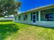 Green backyard shows the house with a screen-in porch and lush green grass at 1157 Valley Creek Run, Winter Park, FL 32792