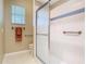 This bathroom has floral wallpaper, shower with glass doors, grab bar and tiled flooring at 1157 Valley Creek Run, Winter Park, FL 32792