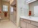 This bathroom has floral wallpaper, shower with glass doors, vanity and mirror with decorative light fixture at 1157 Valley Creek Run, Winter Park, FL 32792