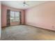 Empty bedroom with pink walls, carpeting, and a large window at 1157 Valley Creek Run, Winter Park, FL 32792
