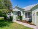 Close-up of the home's manicured landscaping, garden beds, and inviting front entrance with lots of natural light at 1157 Valley Creek Run, Winter Park, FL 32792