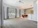 Open-concept living room adjacent to the eat-in kitchen, featuring neutral carpeting and large windows at 1157 Valley Creek Run, Winter Park, FL 32792