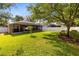 Large backyard featuring a screened patio, green lawn, and mature trees at 1174 Snug Harbor Dr, Casselberry, FL 32707