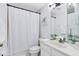 Bathroom features a shower, decorative mirror, and updated vanity at 1174 Snug Harbor Dr, Casselberry, FL 32707
