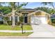 Charming single-story home with a well-manicured lawn, mature trees, and a two-car garage at 1174 Snug Harbor Dr, Casselberry, FL 32707