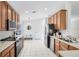 Functional kitchen with stainless steel appliances, wood cabinets, and white tile flooring at 1174 Snug Harbor Dr, Casselberry, FL 32707