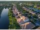 Aerial view showcasing homes bordering a pond, featuring lush greenery and some houses with solar panels on the roof at 11962 Autumn Fern Ln, Orlando, FL 32827
