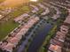 An aerial view of a lovely neighborhood with manicured lawns and a scenic pond running through the community at 11962 Autumn Fern Ln, Orlando, FL 32827