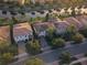 Aerial view features residences with well-maintained landscaping and a pond, some houses are equipped with solar panels at 11962 Autumn Fern Ln, Orlando, FL 32827