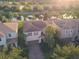 An aerial view captures homes with well-kept lawns and landscaping, situated near a pond and mature trees at 11962 Autumn Fern Ln, Orlando, FL 32827