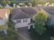 Aerial view of a two-story home with a tile roof, two-car garage, and lush landscaping in a waterfront community at 11962 Autumn Fern Ln, Orlando, FL 32827