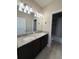 Bathroom with dual sinks, granite countertops, and a large mirror at 11962 Autumn Fern Ln, Orlando, FL 32827