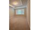 A bright, carpeted bedroom with tray ceiling details and a large window at 11962 Autumn Fern Ln, Orlando, FL 32827