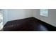 A serene bedroom with beautiful dark floors that complement the neutral walls and natural light streaming through the window at 11962 Autumn Fern Ln, Orlando, FL 32827