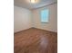 Bright bedroom featuring wood-look floors and a window for natural light at 11962 Autumn Fern Ln, Orlando, FL 32827