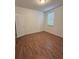 Bright bedroom featuring wood floors, a textured wall, and a window at 11962 Autumn Fern Ln, Orlando, FL 32827