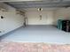 Clean two-car garage with epoxy flooring, shelving, and a water heater, ready for storage and vehicles at 11962 Autumn Fern Ln, Orlando, FL 32827