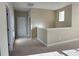 A view of a neutral hallway with carpet and white doors at 11962 Autumn Fern Ln, Orlando, FL 32827